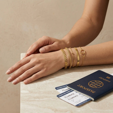 elegant woman wearing multiple gold bracelets stacked on wrist, refined jewelry set inspired by travel and personal expression, Woodstock Zambon
