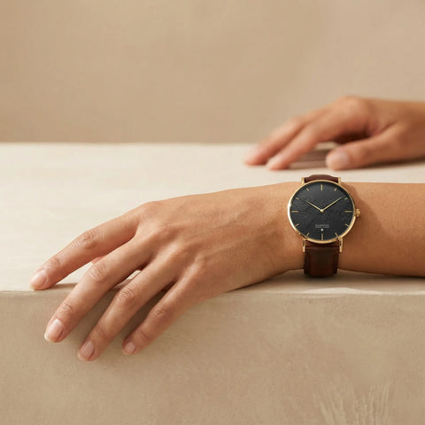 Elegant brown minimalist world map watch with gold case and leather strap by Woodstock Zambon worn on wrist