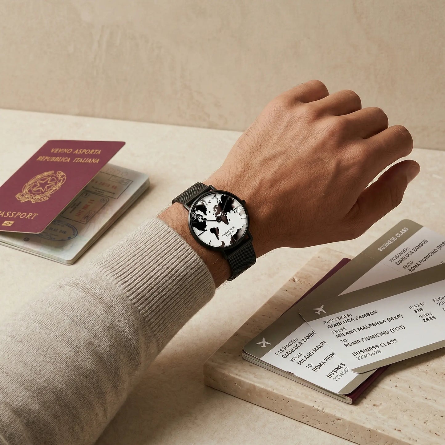 Men's black and white world map watch Woodstock Zambon worn on wrist with passport and airline tickets